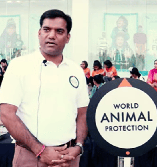 A man with microphone on his collar standing next to a World Animal Protection sign