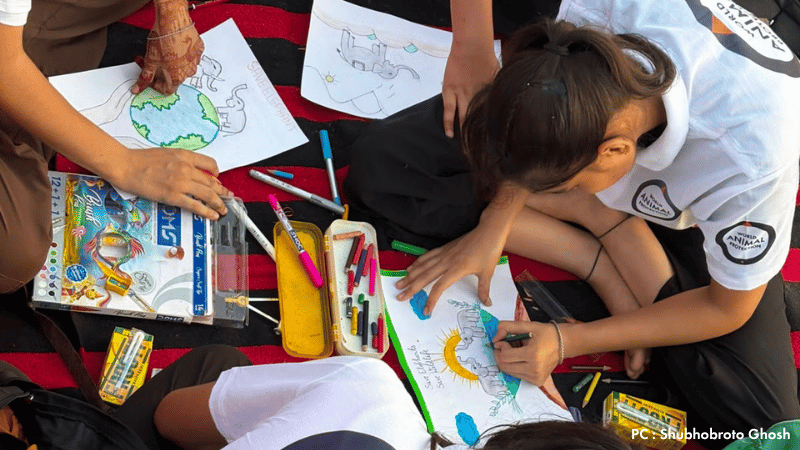 Young participants hold artwork and banners promoting wildlife conservation during a World Environment Day event in Jaipur.